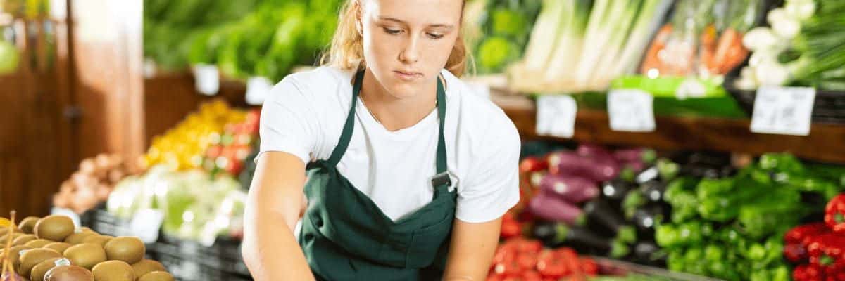 grocery store worker restocking produce