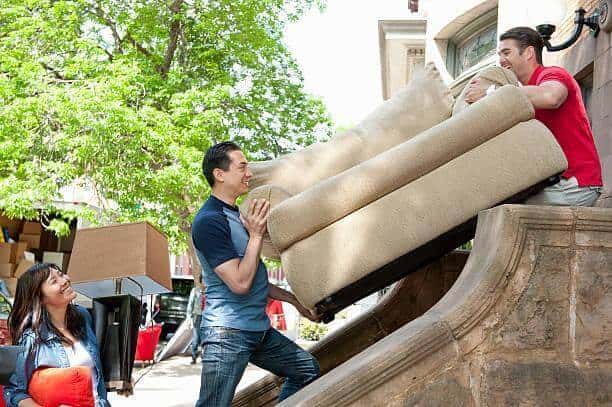 Two males removing an old couch.