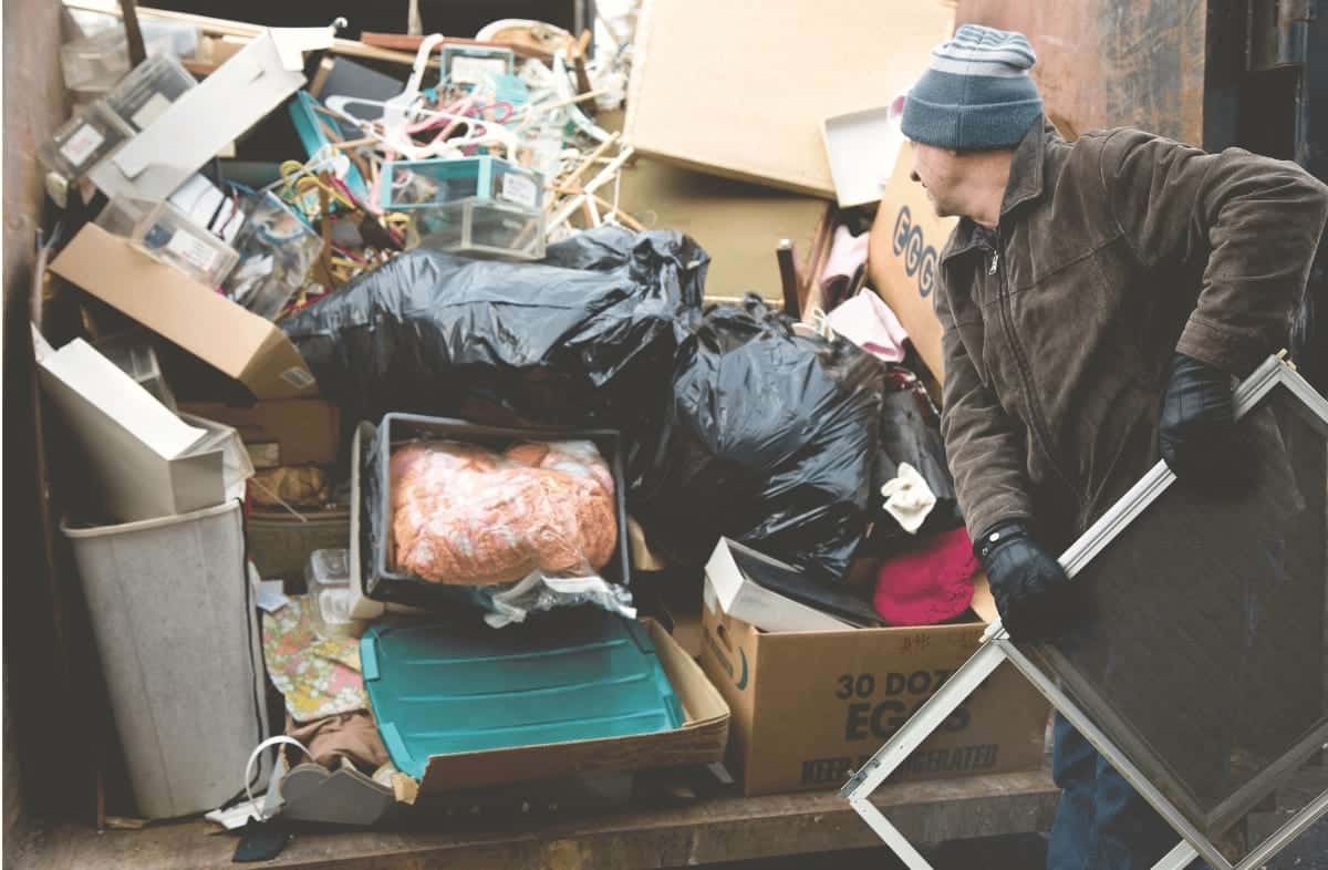 Person loading bulk waste into a truck illustrating emergency bulk waste removal services.