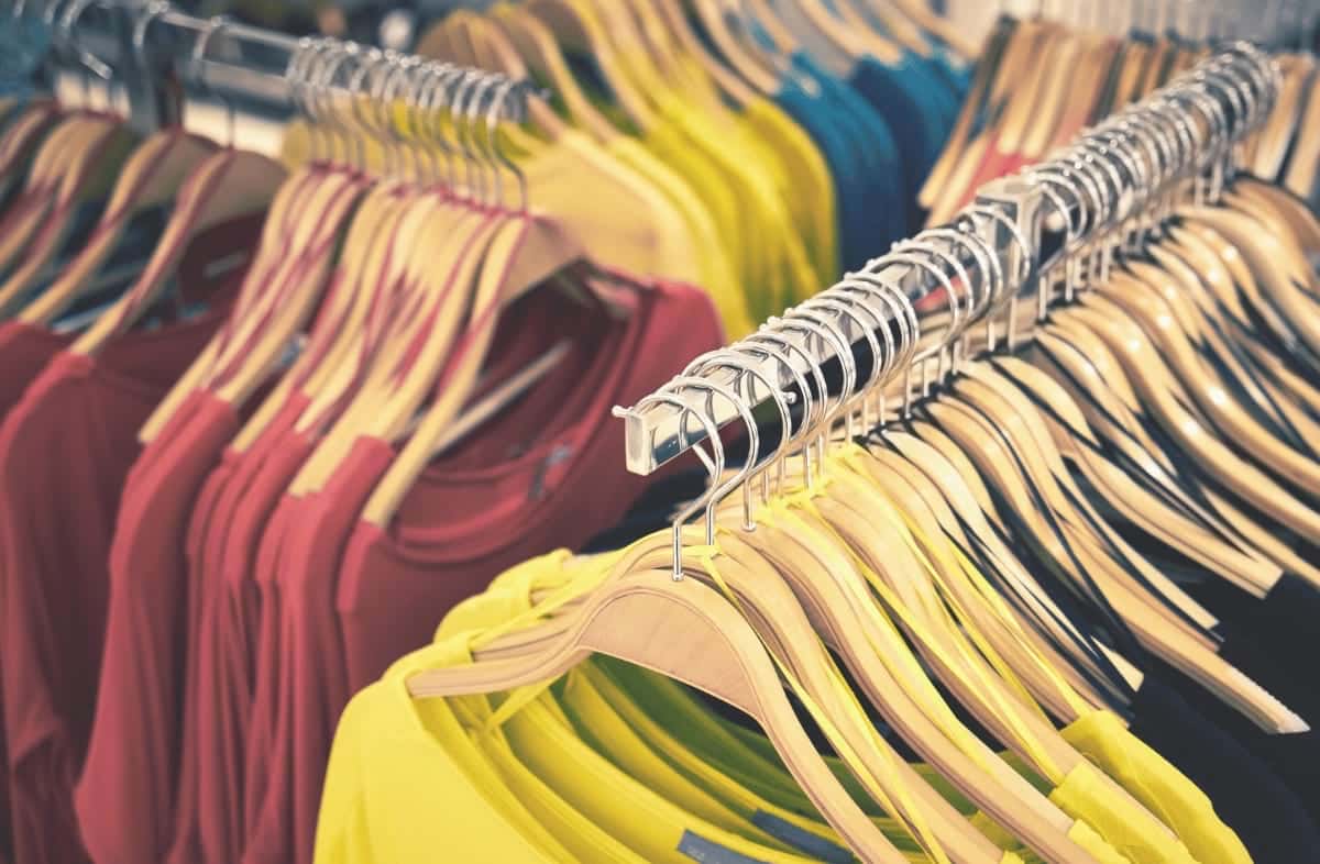 Retail clothing racks illustrating the need for emergency bulk waste removal to maintain a clean store environment.